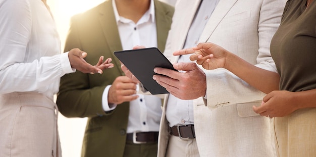 Hands tablet e collaborazione con un team aziendale che lavora alla ricerca insieme nel loro ufficio Riunione di lavoro di squadra o pianificazione con un gruppo di dipendenti uomo e donna che discute la strategia sul lavoro