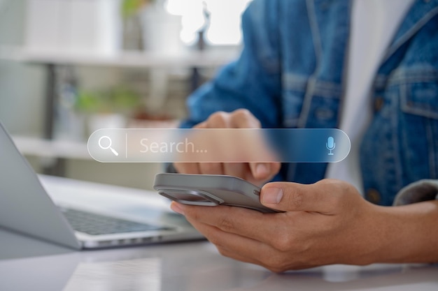 hands using a smartphone and laptop with a virtual search bar symbolizing data search technology and SEO optimization in digital marketing