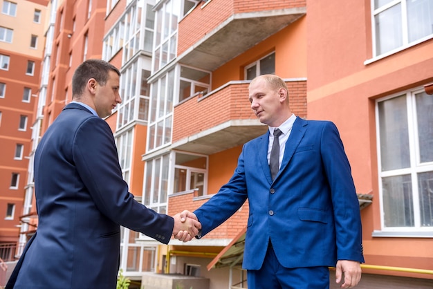 Handshaking dei partner commerciali vicino all'edificio per uffici all'aperto