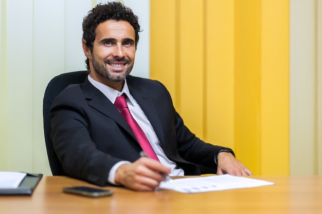 Handsome uomo d&#39;affari al suo banco in ufficio