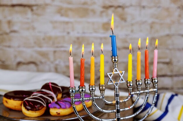 Hanukkah flatlay Hanukkah caramelle sufganiot menorah candele multicolori e ciambelle