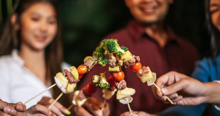 Happy Asian friends cheering with barbecue dinner outdoor Group of people having fun in new year party People food and drink lifestyle concept Night Party people and celebration concept