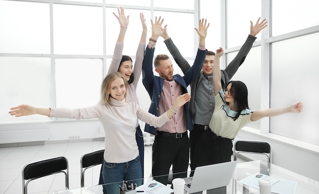 Happy business team che mostra il proprio successo vicino al desktop