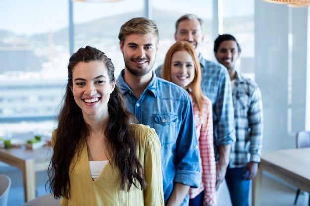 Happy business team creativo in piedi in una linea in ufficio