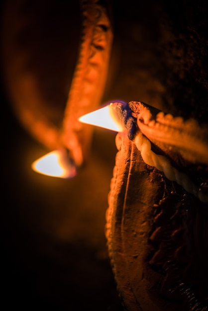 Happy Diwali - molte lampade diya o olio in terracotta disposte su una superficie di argilla o macinate in una linea o forma curva o a zigzag, messa a fuoco selettiva