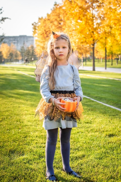 Happy Halloween Bambina carina in costume da strega con un bambino zucca e caramelle è triste e sconvolta