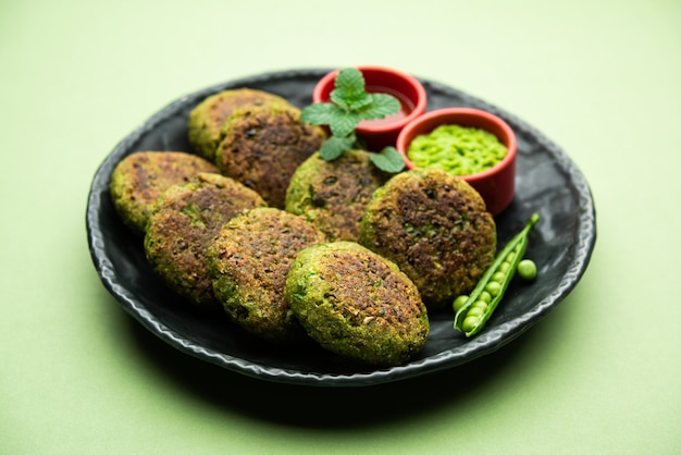 Hara bhara Kabab o Kebab è uno spuntino vegetariano indiano servito con chutney di menta verde su una superficie lunatica. messa a fuoco selettiva