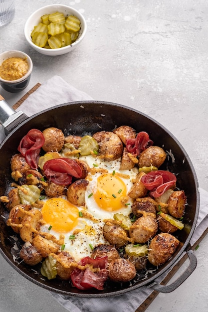 Hash di patate con uova fritte e pastrami di carne per il ramo della colazione