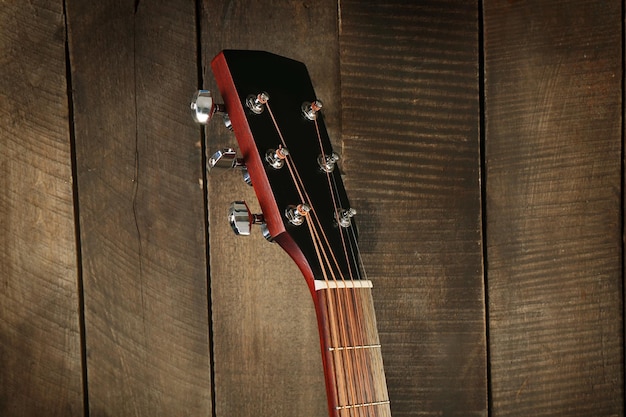 Headstock sullo sfondo di una parete di legno in primo piano