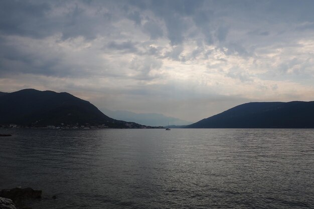 Herceg Novi Montenegro Vacanze al mare al mare Gite in mare Le barche galleggiano sul Mar Adriatico Affari di viaggio nel Mediterraneo Barche a vela e montagne Piccole increspature sull'acqua salata Il cielo si riflette nelle onde