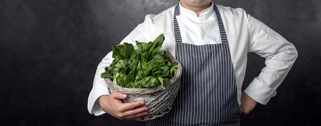 Hhand tiene in mano un cestino con insalata verde