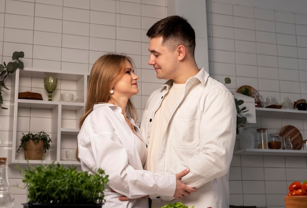 Hhappy amore coppia che si abbraccia a casa cucina interna data interna