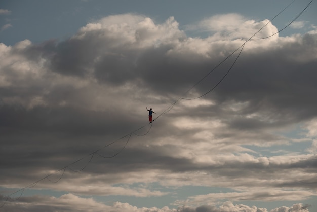 Highliner contro uno sfondo di cielo drammatico. Tema Slackline