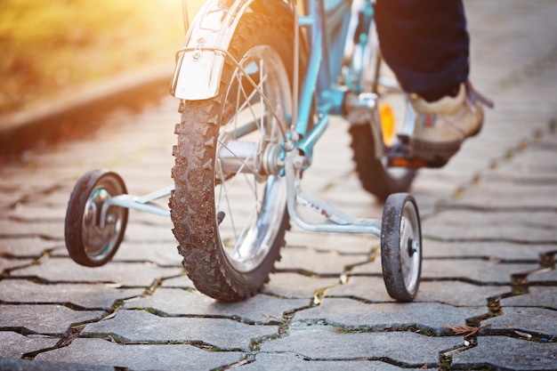 ? Hild su una bicicletta in strada asfaltata in giornata di sole. Vista posteriore