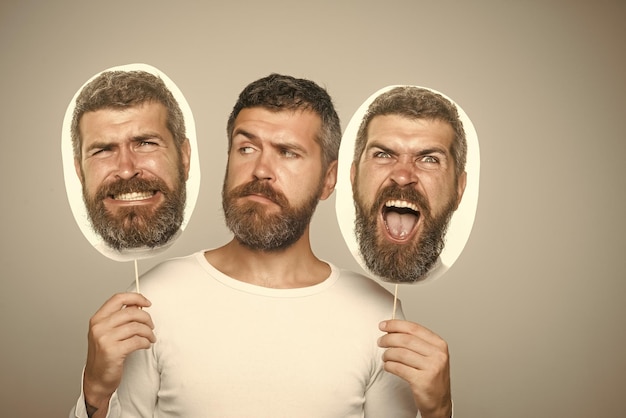 Hipster con faccia seria e arrabbiata tenere ritratto targhetta Sensazione ed emozioni Uomo con barba lunga e baffi Ragazzo o uomo barbuto su sfondo grigio Barbiere moda e bellezza