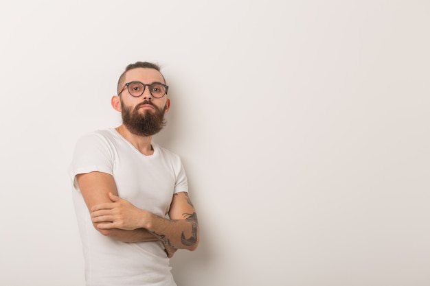 Hipster, concetto di persone - ragazzo hipster con gli occhiali con le braccia incrociate su uno sfondo bianco.