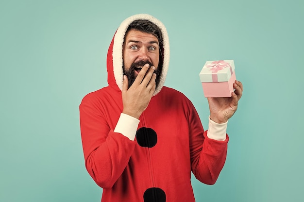 Hipster maschio sorpreso con barba e baffi che indossa il costume di Babbo Natale per la celebrazione della festa di Natale con confezione regalo venerdì nero