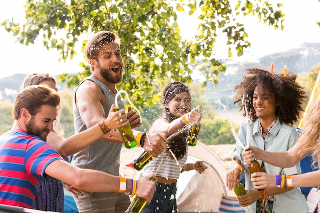 Hipsters che spruzzano birra sopra a vicenda