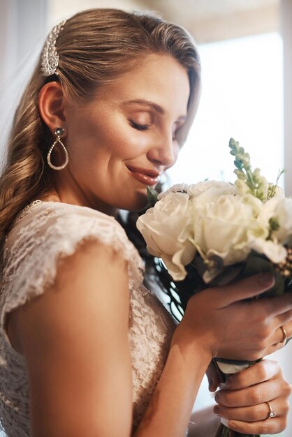 Hmm hanno un odore incredibile Foto ritagliata di una giovane sposa attraente in piedi nel camerino da sola e annusando il suo mazzo di fiori