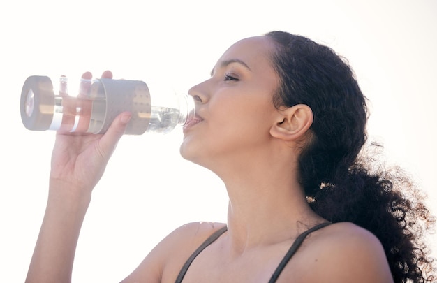 Ho bisogno di acqua Foto ritagliata di una giovane donna in forma che beve acqua mentre è fuori per un allenamento