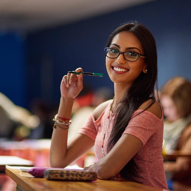 Ho intenzione di superare i miei esami Ritratto di una bellissima studentessa universitaria che prende appunti mentre è seduta in un'aula magna