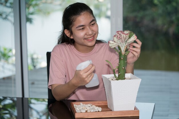 Hobby delle ragazze adolescenti La giovane donna ha decorato un cactus nel soggiorno di casa