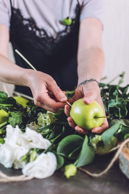 Hobby e attività, arti e mestieri durante il coronavirus. La donna del fiorista fa il mazzo commestibile della frutta Naturalezza, Composizioni floreali, trucchi da fiorista, consigli, tendenze.