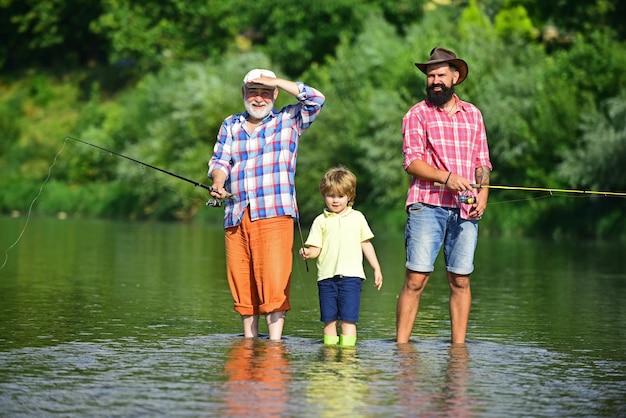 Hobby e attività sportive uomo che insegna ai bambini come pescare nel fiume felice nonno padre e nipote