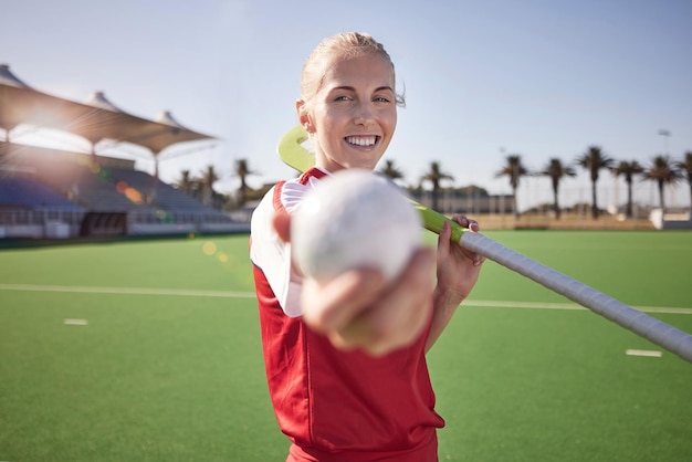 Hockey sportivo e donna con fitness sul campo atleta nel ritratto dello stadio felice con l'esercizio all'aperto Giocatore di hockey palla e bastone sul tappeto erboso pronto per l'allenamento di gioco e la motivazione sportiva