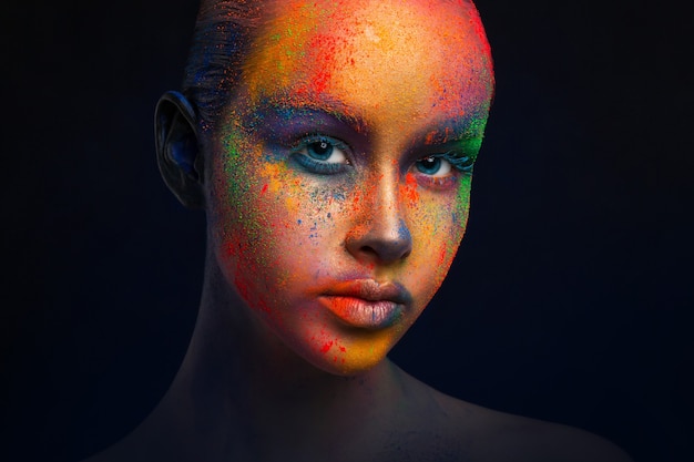 Holi festival dei colori. Arte del viso femminile con trucco creativo. ritratto di giovane modella