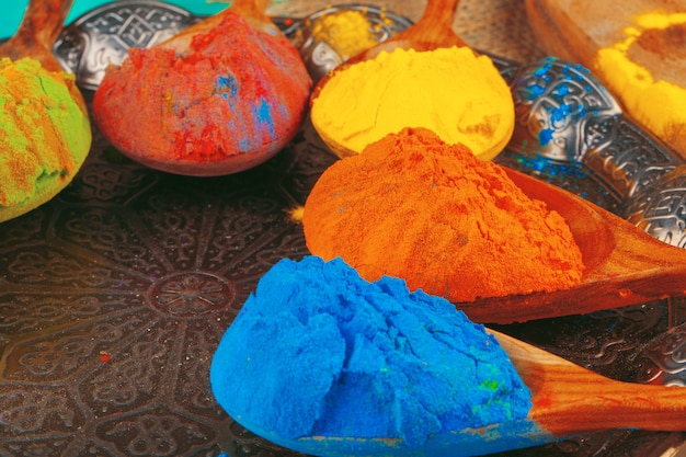 Holi indiano tradizionale colora la polvere, spezie sulla parete rustica scura