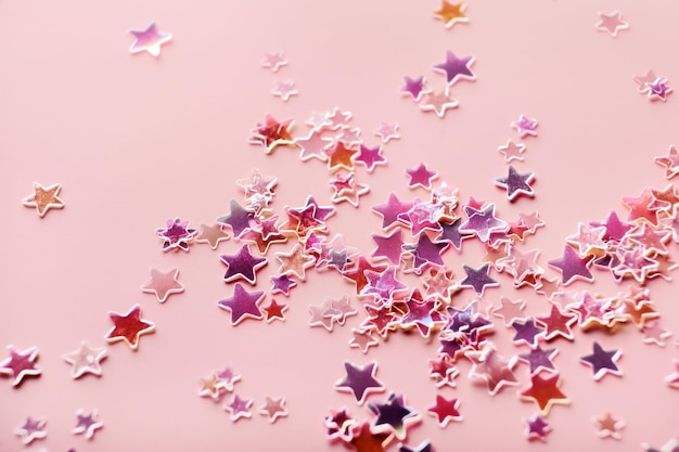 Holografico rosa e viola Stelle Glitter Confetti su sfondo rosa sfondo festivo messa a fuoco selettiva