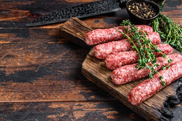 Homamade carne cruda lula kebab salsicce su un tagliere. Fondo in legno scuro. Vista dall'alto. Copia spazio.