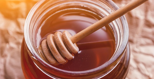 Honey Dipper in un barattolo con miele fresco