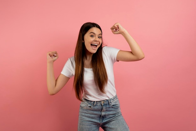 Hooray ragazzina gioiosa che scuote i pugni chiusi ardendo e rallegrandosi del successo