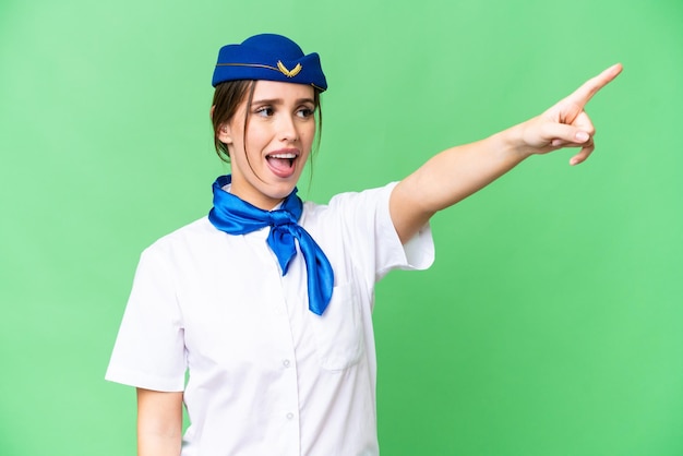 Hostess di aeroplano su sfondo chroma key isolato che punta lontano