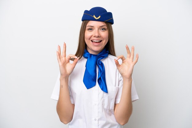 Hostess donna lituana dell'aeroplano isolata su sfondo bianco che mostra un segno ok con le dita