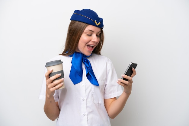 Hostess donna lituana dell'aeroplano isolata su sfondo bianco che tiene il caffè da portare via e un cellulare