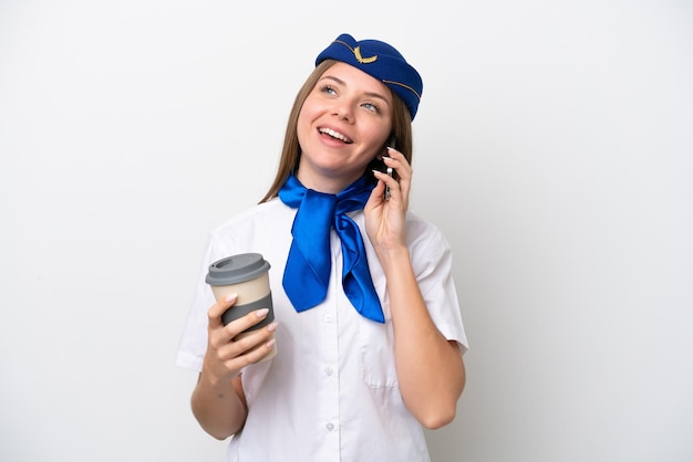 Hostess donna lituana dell'aeroplano isolata su sfondo bianco che tiene il caffè da portare via e un cellulare