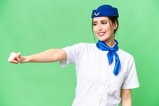 Hostess in aereo su sfondo chroma key isolato che dà un gesto del pollice in alto