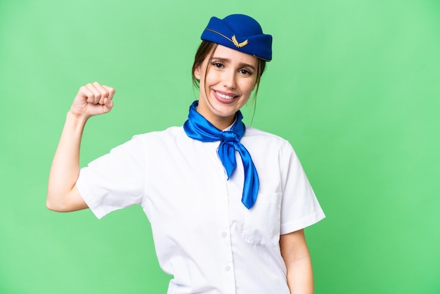 Hostess in aereo su sfondo chroma key isolato facendo un gesto forte