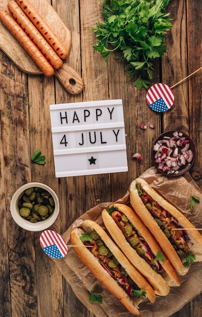 Hot dog alla griglia con barbecue con cipolla rossa di cetriolo sottaceto e senape su fondo di legno rustico Vista dall'alto