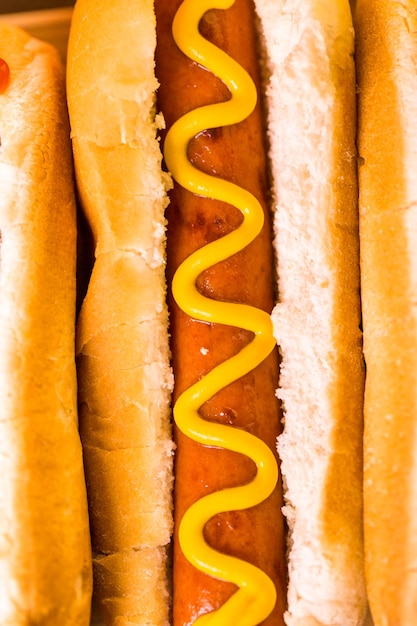 Hot dog alla griglia su panini bianchi per hot dog con senape e ketchup.