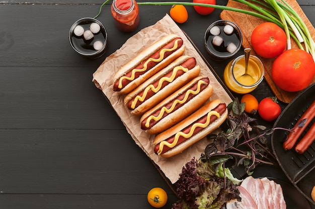 Hot dog americano con ingredienti su un fondo di legno scuro