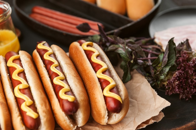 Hot dog americano con ingredienti su uno sfondo di legno scuro