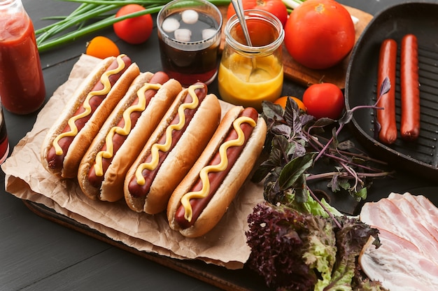 Hot dog americano con ingredienti su uno sfondo di legno scuro