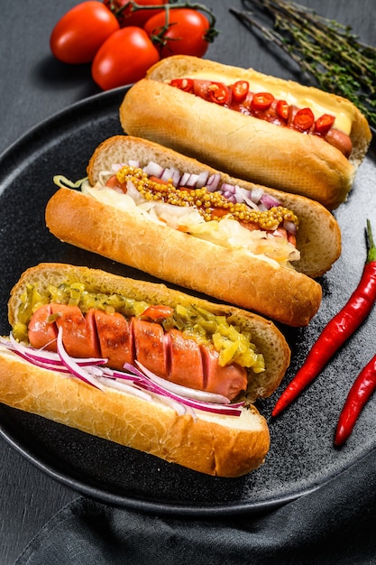 Hot dog completamente caricati con condimenti assortiti su un vassoio