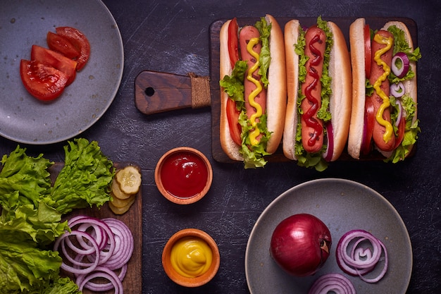 Hot dog con salsiccia, cipolla fritta, foglie di coriandolo, salsa di formaggio e senape. Fast food. Vista dall'alto, copia spazio