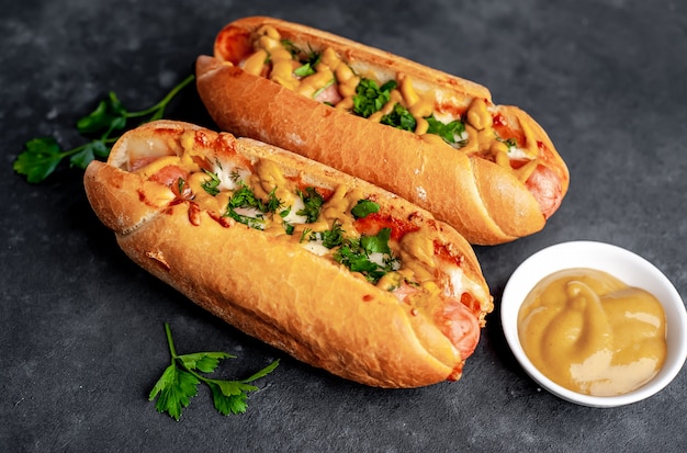 hot dog francesi al forno con formaggio e senape su uno sfondo di pietra