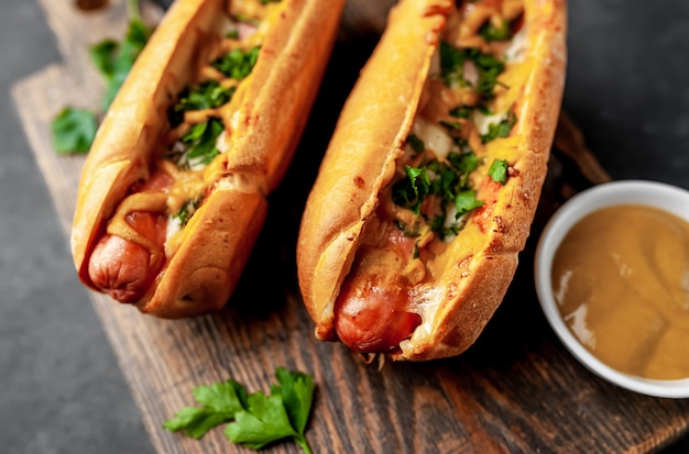 hot dog francesi al forno con formaggio e senape su uno sfondo di pietra